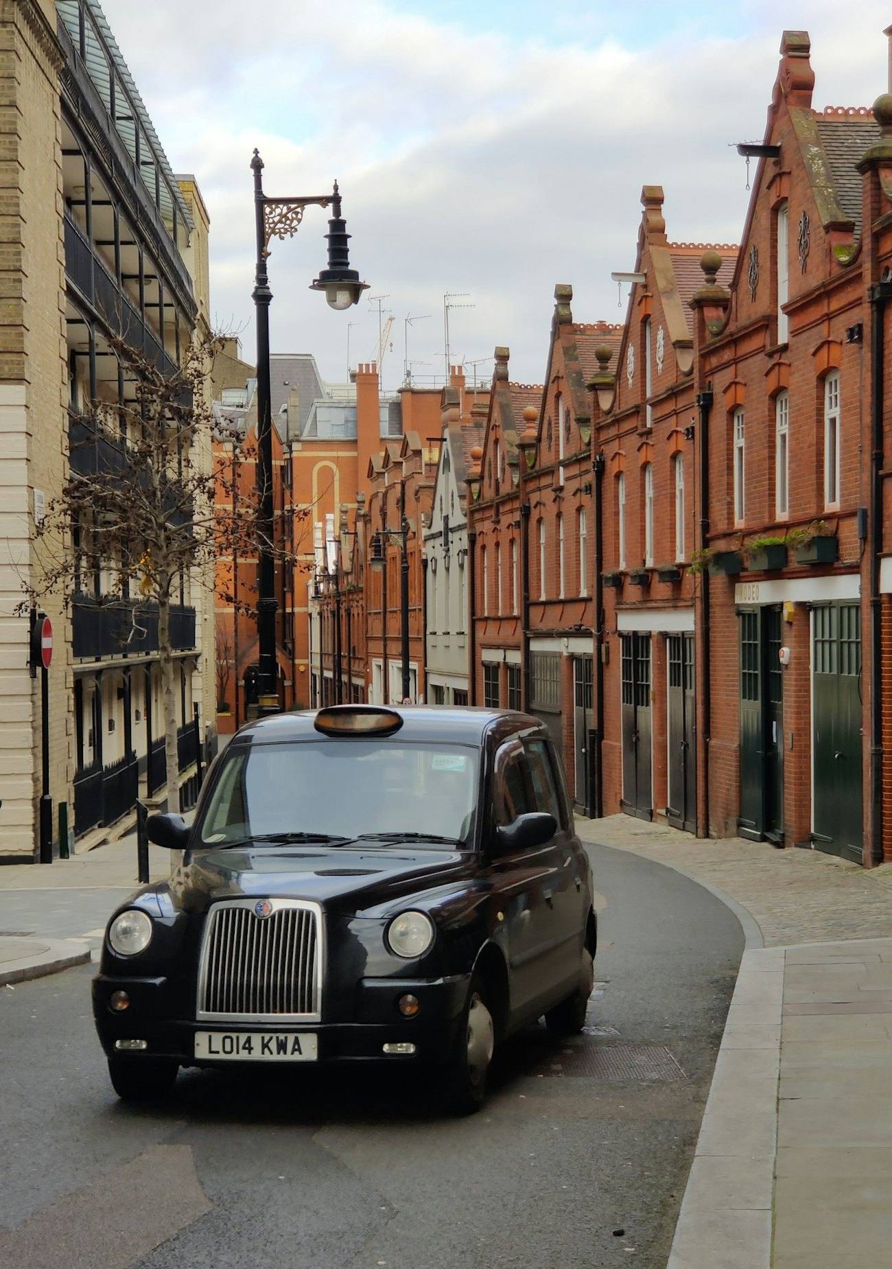A black cab on a street of red brick buildings